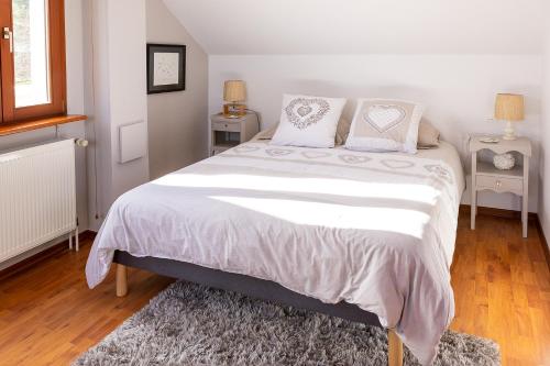 a bedroom with a large bed with white sheets and pillows at Studio spacieux, route des vins in Rosheim