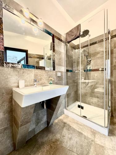 a bathroom with a sink and a shower at NURAS - Joia city center in Alghero