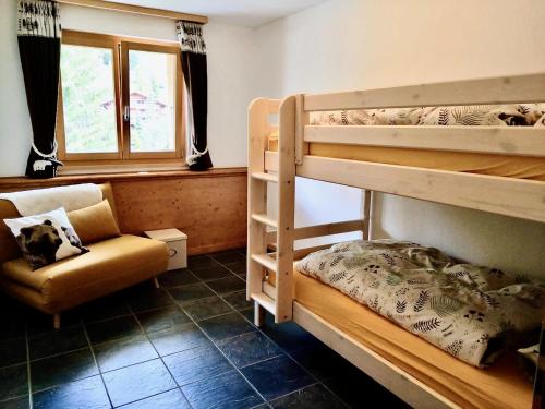 a room with bunk beds and a chair and a window at Le Charme 1, Morgins in Morgins
