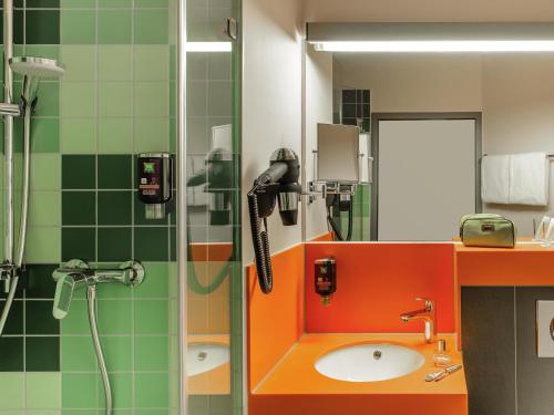 a bathroom with a shower and a sink and a phone at ibis Styles Speyer in Speyer