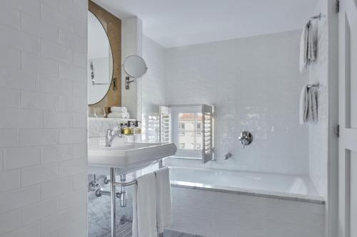 ein weißes Badezimmer mit Waschbecken und Badewanne in der Unterkunft Pulitzer Amsterdam in Amsterdam