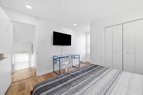 a bedroom with a bed and a tv on a wall at Dormont, Pittsburgh !A Spacious and Modern Private Bedroom with Shared Bathroom in Pittsburgh