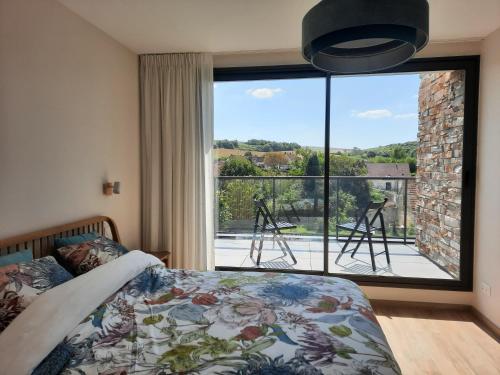 a bedroom with a bed in front of a large window at Au Bon Cap in Hervelinghen
