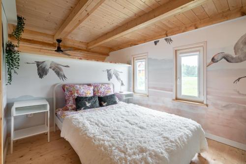 a bedroom with a bed with birds on the wall at Czaplowisko - skandynawskie domy na Kaszubach in Stare Czaple