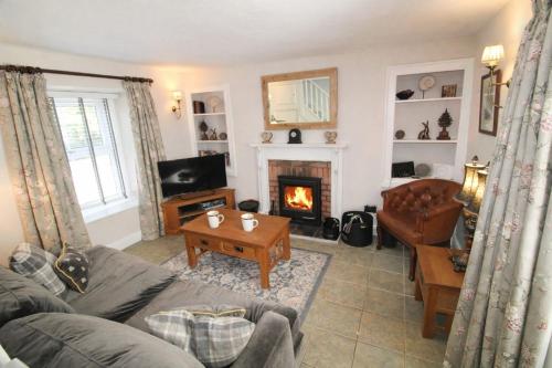a living room with a couch and a fireplace at Kirkstone Cottage ideal for a romantic break centrally located in Ambleside with wood burning stove in Ambleside