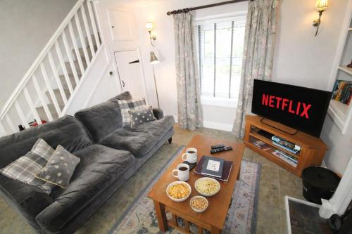 a living room with a couch and a table at Kirkstone Cottage ideal for a romantic break centrally located in Ambleside with wood burning stove in Ambleside