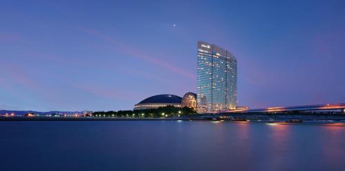 a tall building next to a large body of water at Hilton Fukuoka Sea Hawk in Fukuoka