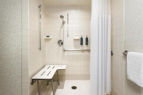 a shower with a bench in a bathroom at DoubleTree by Hilton San Jose in San Jose