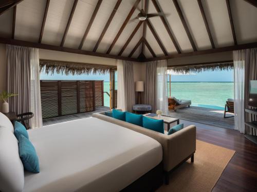 a bedroom with a bed and a living room at Conrad Maldives Rangali Island in Mandhoo