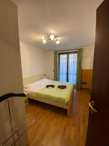 a bedroom with a bed and a window at Rosadira Vista Lago sulle Dolomiti in Auronzo di Cadore