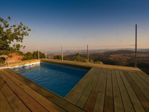 a swimming pool on a wooden deck with a view at Red and White אדום לבן in Amirim