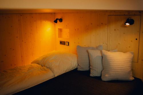 a bed with white pillows in a room at cabinski Montafon in Sankt Gallenkirch