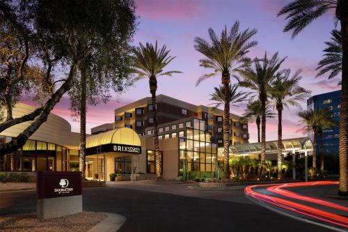 a hotel with palm trees in front of a building at DoubleTree Suites by Hilton Phoenix in Phoenix