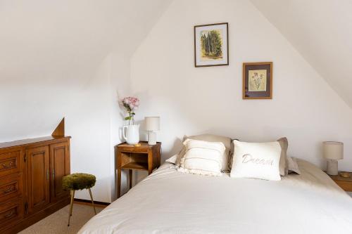 a bedroom with a white bed with two pillows at Appartement 1 chambre terrasse et piscine in Boersch