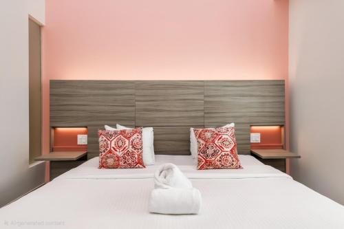 a bedroom with a large white bed with red pillows at The Julia Hotel in Miami Beach