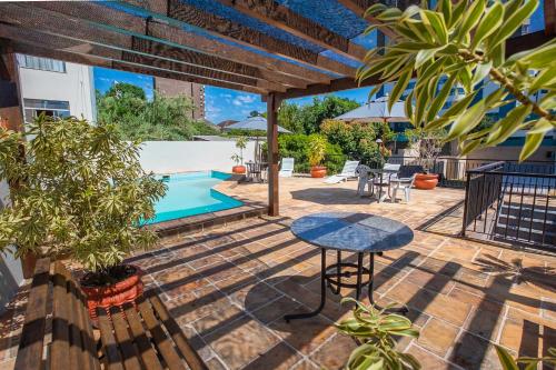 a patio with a table and a swimming pool at Hotel Suárez Executive Novo Hamburgo in Novo Hamburgo