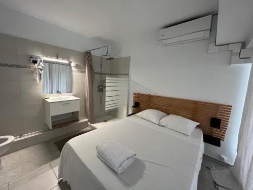 a white bedroom with a bed and a sink at Le Loft in Pointe-à-Pitre