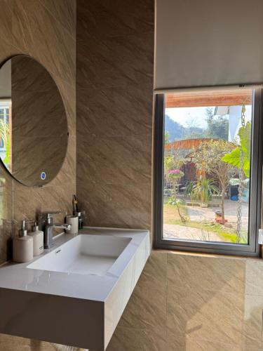 a bathroom with a white sink and a mirror at Mộc Sơn Homestay in Mộc Châu