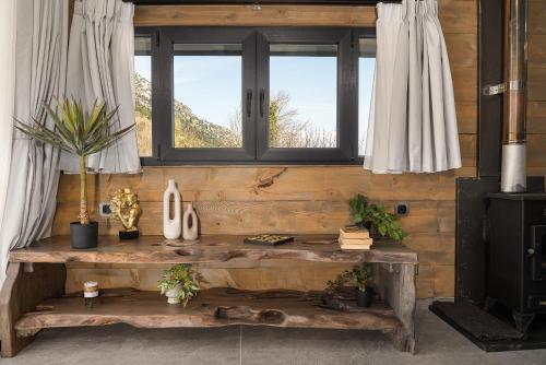 a wooden bench in a room with two windows at LF Parnassos Chalet in Eptalofos