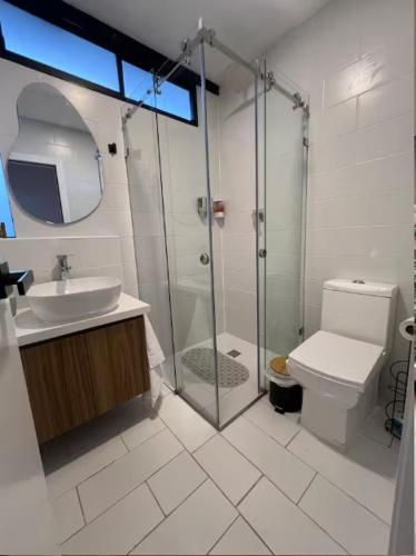 a bathroom with a shower and a toilet and a sink at Cuenca Hotel Apartment in Cuenca