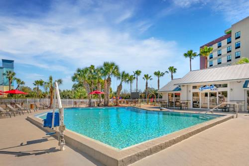a pool at a resort with chairs and umbrellas at Orlando International Drive North Hotel in Orlando