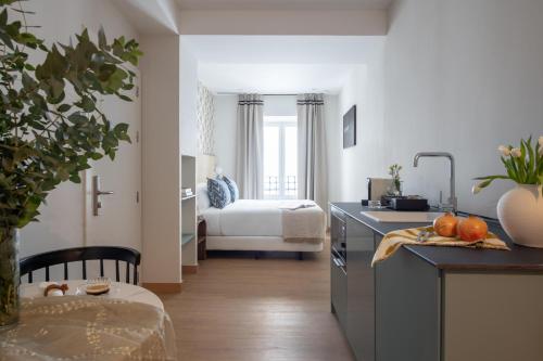 a kitchen with a sink and a bedroom with a bed at Casa Carver 1927 by Hommyhome in Seville