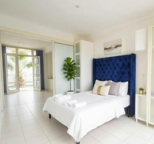 a bedroom with a large bed with a blue headboard at ALBACHIARA INN Residence Apartments in Ameglia