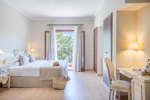 a white bedroom with a bed and a window at Hotel Cala Fornells in Paguera
