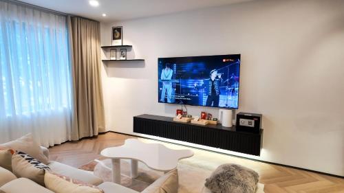 a living room with a large tv on a wall at Metrolux By ZG in Ho Chi Minh City