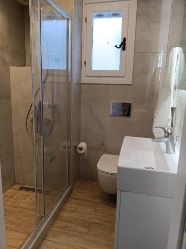 a bathroom with a shower and a toilet and a sink at Philly's sea side apartment in Agios Ioannis Pelio