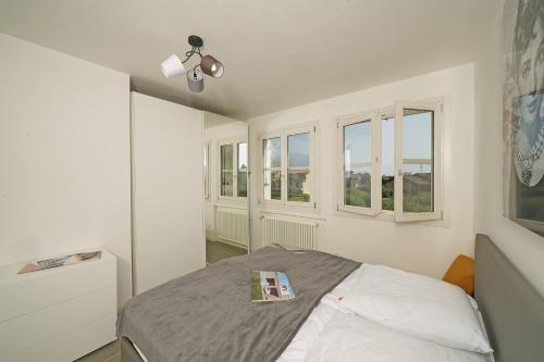 a bedroom with a bed with a book on it at Corte Fasanella 31 - Gardagate in Toscolano Maderno