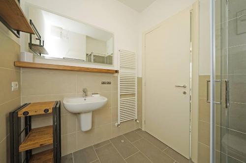 a small bathroom with a sink and a shower at Corte Fasanella 31 - Gardagate in Toscolano Maderno