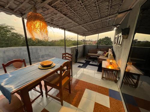 a room with a table and chairs on a balcony at Villa La Somone piscine jardin personnel sur place in Somone