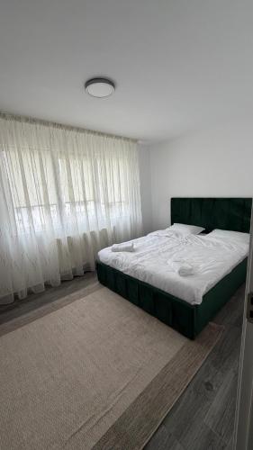 a bedroom with a large bed and white curtains at Luxury Lion Crib2 in Bacău