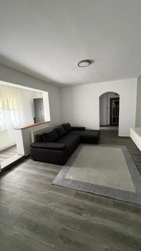 a living room with a black couch and a rug at Luxury Lion Crib2 in Bacău