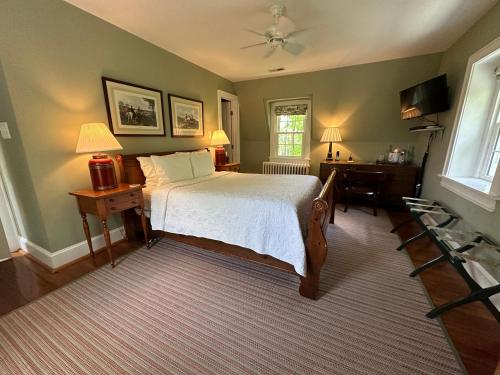 a bedroom with a bed and a desk and a window at Goodstone Inn & Restaurant in Middleburg