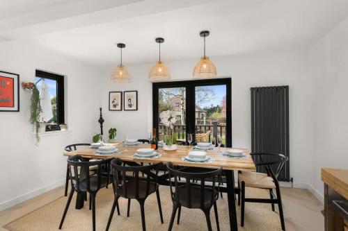 a dining room with a wooden table and black chairs at Gilmore House - 5 Bedroom Victorian Home with Hot Tub in Blairgowrie