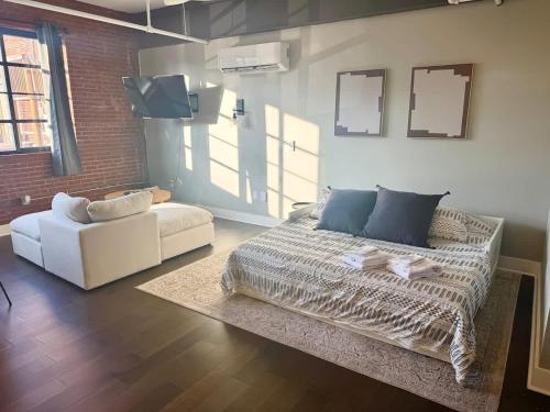 a living room with a bed and a couch at Studio Apt King Bed Full Kitchen By KeenStays in Cape Girardeau