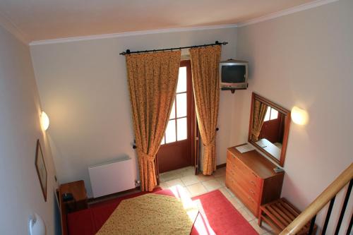 a bedroom with a bed and a television and a window at Hotel Rural Quinta de Sao Sebastiao in Barroselas