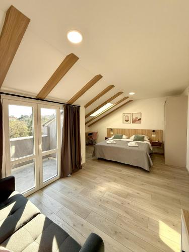 a bedroom with a bed and a large window at Cloud9 Airport Suites in Močići