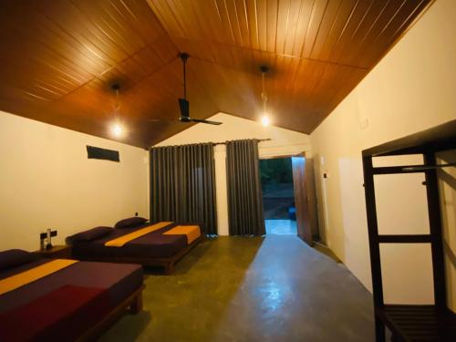 a bedroom with two beds and a wooden ceiling at Villu Trails Wilpattu in Wilpattu
