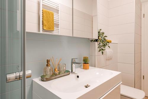 a white bathroom with a sink and a mirror at Waterfront Luxury Residence - Paid Parking Option in Budapest