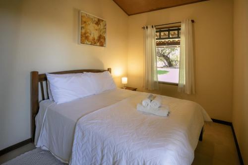a bedroom with a bed with two towels on it at Casa Manoel Facão in Atins