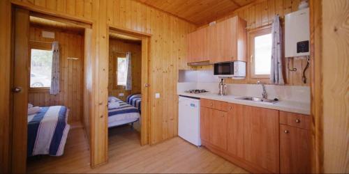 a kitchen in a wooden cabin with a sink at Camping Ametlla in L'Ametlla de Mar