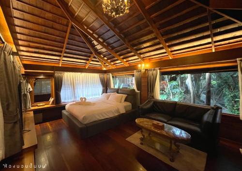 a large bedroom with a bed and a couch at River tales ริเวอร์เทลส์แก่งกระจาน in Phetchaburi