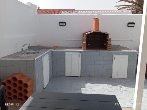 an outdoor kitchen with a sink and a stove at Casa Joy in La Oliva