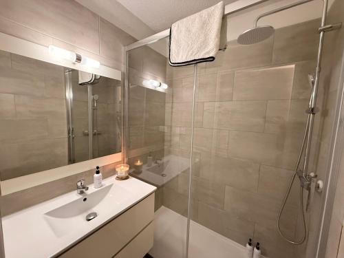 a bathroom with a sink and a glass shower at Le Cosy du Lagon bleu in Fréjus