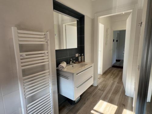 a white bathroom with a sink and a mirror at Sottovento Beths House in Brenzone sul Garda
