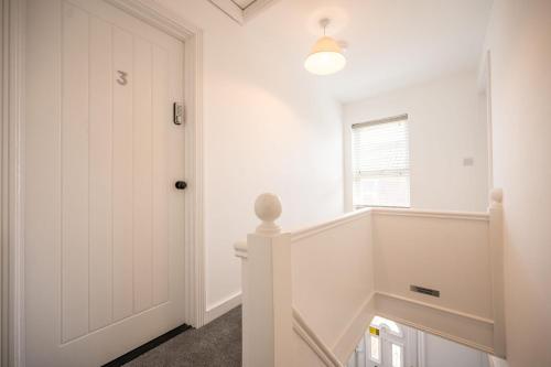 a hallway with a white door and a window at 38 Prospect Place, Leiston in Leiston