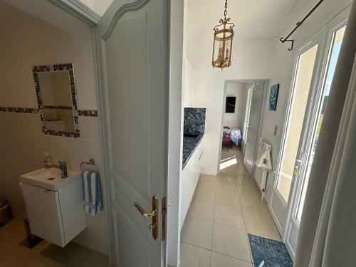 Hautot-sur-MerにあるGarden-level studioの洗面台とトイレ付きのバスルームのある廊下